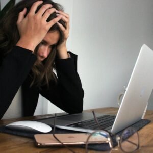 a woman sitting in front of a laptop computer